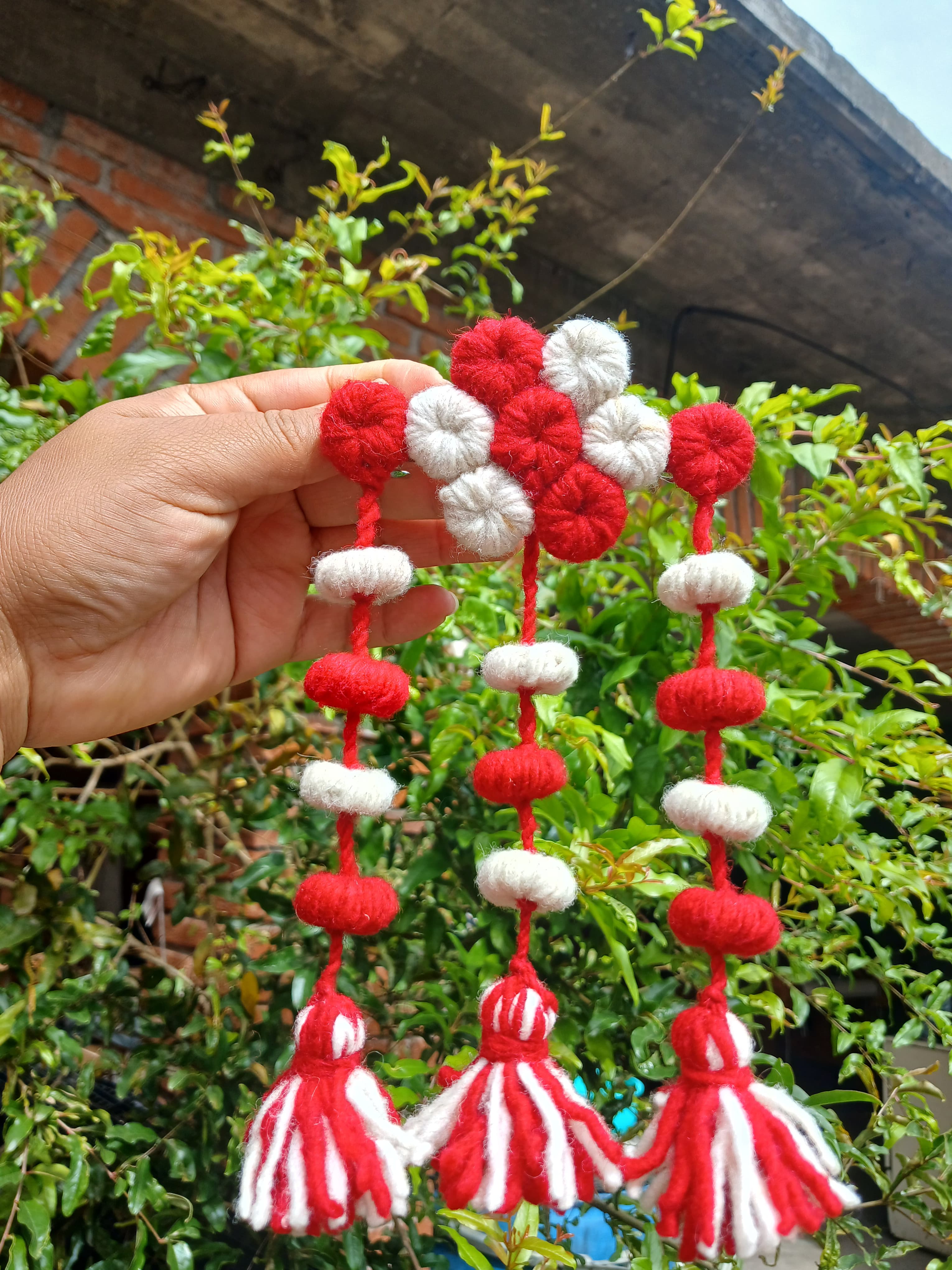 Colgante artesanal de estambre con 3 muñequitas y pompones