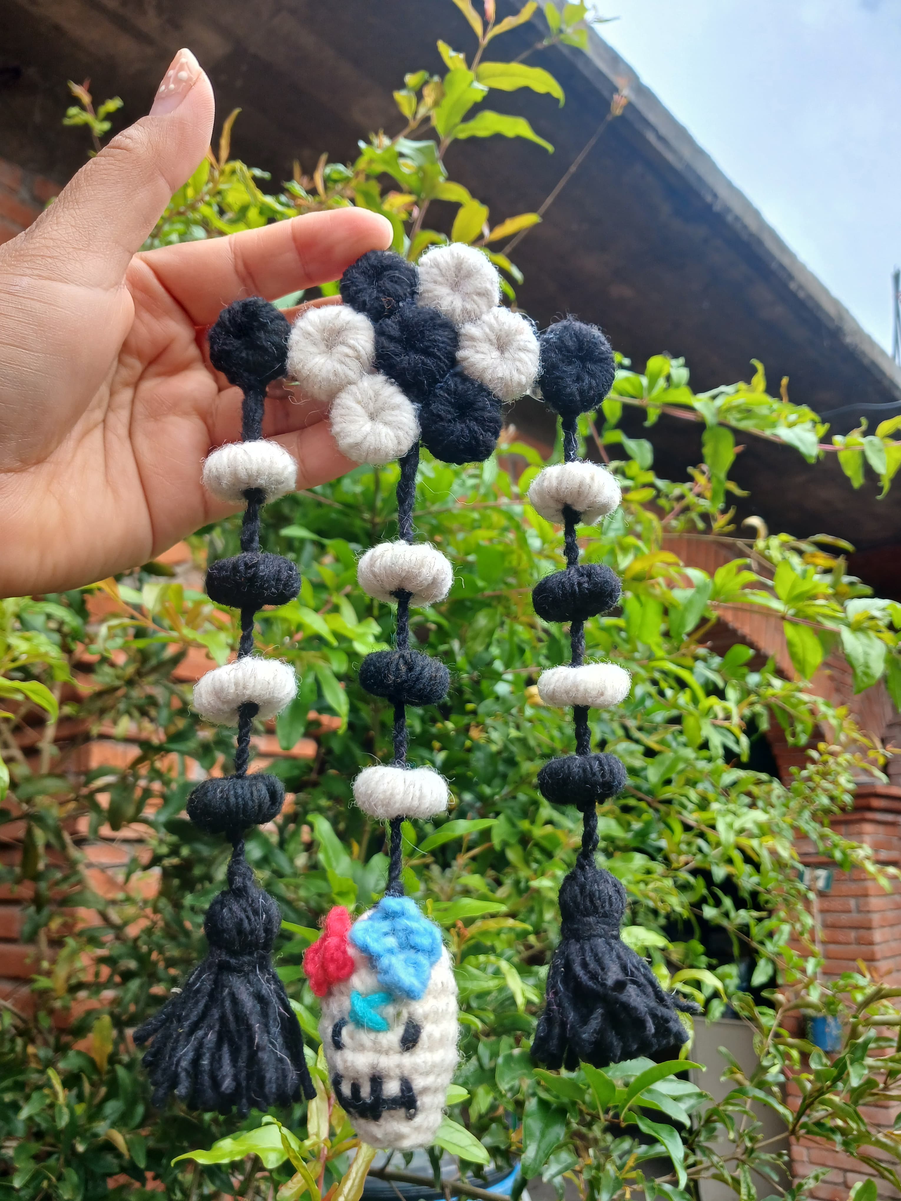 Colgante artesanal de calavera con pompones y borlas