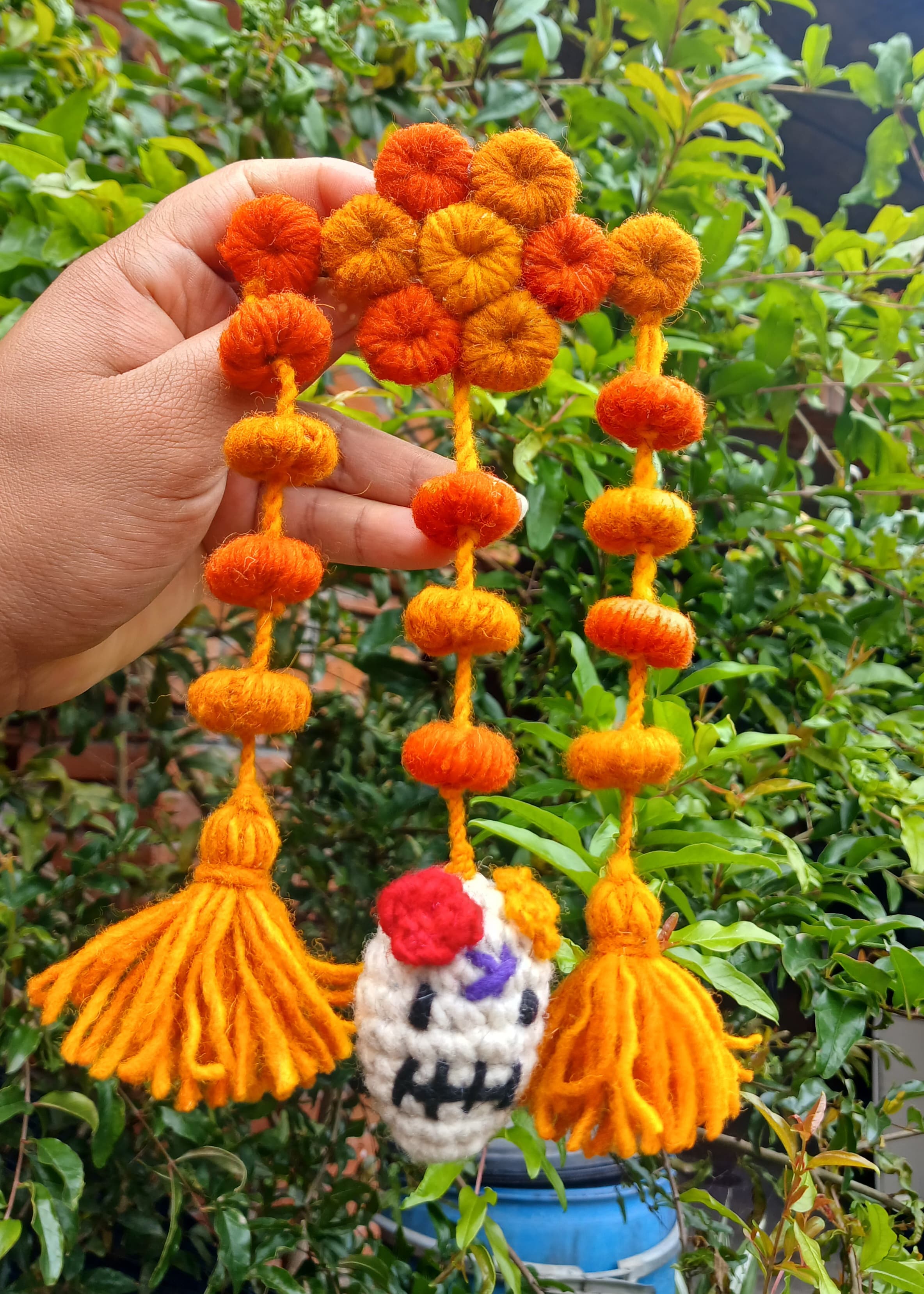 Colgante artesanal de calavera de Día de Muertos con pompones y borlas